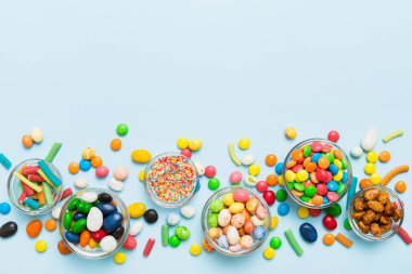 farklı renkte yuvarlak şekerler ve kavanozlar. Fotokopi alanı olan büyük çeşitlilikteki şeker ve şekerlerin üst görünümü.