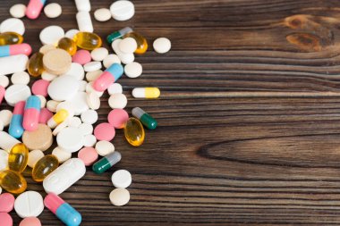 Çeşitli ilaç ve haplardan oluşan bir koleksiyon. Masa arkasında çeşitli ilaç hapları, haplar ve kapsüller var. Çeşitli ilaç tabletleri yığını. Sağlık hizmetleri.