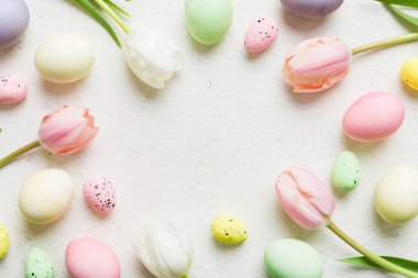 Mutlu Paskalya kompozisyonu. Renkli masada sarı laleli Paskalya yumurtaları. Doğal boyalı renkli yumurtalar arkaplan arkaplan görünümü kopya alanı ile.