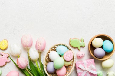Yumurtalı Paskalya çerçevesi, renkli bir arka planda hediye kutusu ve lale. Minimum konsept. Üst Manzara Mutlu Paskalyalar kompozisyonu. Metin için yerin bir kopyasına sahip kart.