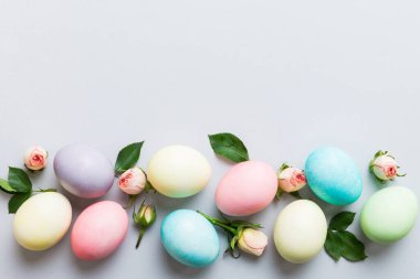 Mutlu Paskalyalar. Renkli masada sarı güllü Paskalya yumurtaları. Doğal boyalı renkli yumurtalar arkaplan arkaplan görünümü kopya alanı ile.
