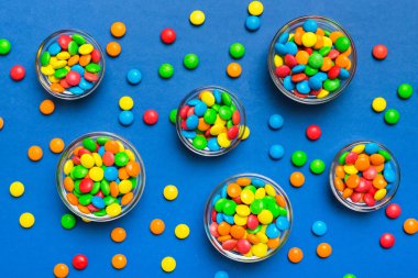 farklı renkte yuvarlak şekerler ve kavanozlar. Fotokopi alanı olan büyük çeşitlilikteki şeker ve şekerlerin üst görünümü.