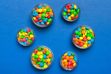 farklı renkte yuvarlak şekerler ve kavanozlar. Fotokopi alanı olan büyük çeşitlilikteki şeker ve şekerlerin üst görünümü.