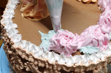 Şekerci kadın pastaya krema döküyor. Pasta poşeti kullanıyor, yakından bakıyor. Pasta şefi ev yapımı kek pişiriyor. Pişirme, pişirme ve pişirme, ev yemeği.