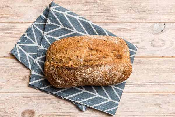 Taze ev yapımı tam buğday ekmeği. Peçetedeki ekmek kırsal arka planda, taze ekmek üst görünümü.