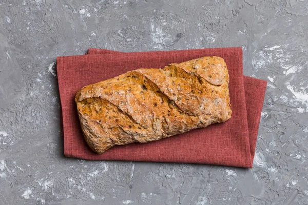 Renkli bir masada buğday ve glüten ile taze somunlar. Peçetedeki ekmek kırsal arka planda, taze ekmek üst görünümü.