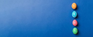 Bayram hazırlığı. Renkli arka planda Paskalya yumurtaları. Pastel renginde Paskalya yumurtası. Kopyalama alanı olan tatil kavramı.
