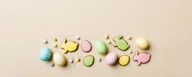bayram hazırlığı renkli arka planda kurabiyeli çok renkli Paskalya yumurtaları. Pastel renginde Paskalya yumurtası. Kopyalama alanı olan tatil kavramı.