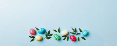 Beyaz arka planda yay yaprağı olan renkli Paskalya yumurtaları. Renkli Yumurta Tatil Kenarı.