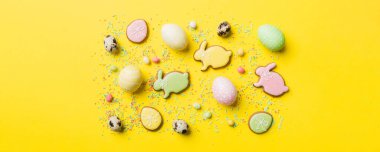 bayram hazırlığı renkli arka planda kurabiyeli çok renkli Paskalya yumurtaları. Pastel renginde Paskalya yumurtası. Kopyalama alanı olan tatil kavramı.