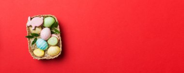 Renkli arka planda dokuma sepetinde çok renkli Paskalya yumurtaları. Pastel renginde Paskalya yumurtası. Kopyalama alanı olan tatil kavramı.