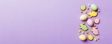 bayram hazırlığı renkli arka planda kurabiyeli çok renkli Paskalya yumurtaları. Pastel renginde Paskalya yumurtası. Kopyalama alanı olan tatil kavramı.