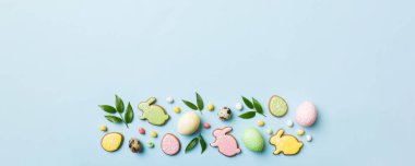 bayram hazırlığı renkli arka planda kurabiyeli çok renkli Paskalya yumurtaları. Pastel renginde Paskalya yumurtası. Kopyalama alanı olan tatil kavramı.