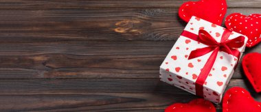 Sevgililer veya diğer tatil el yapımı mevcut kağıt ile tatil sarmalayıcı kırmızı kalpler ve hediye kutusunda. Tasarım için kopya alanı görünümüyle koyu ahşap masa üstü, boş alanı hediye kutusu.