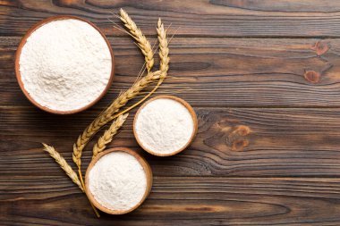 Tahta kasede buğday unu ve renkli arka planda buğday dikenleri. dünya buğday krizi.