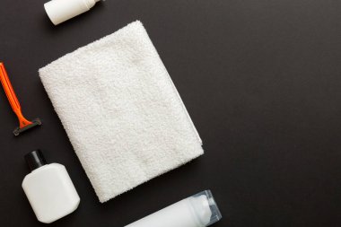 Tıraş Adam seti. Traş makinesi, havlu, losyon ve renkli arka planda tıraş köpüğü. Erkekler banyo aksesuarları üst görünüm.
