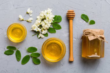 Akasya çiçekli ve yapraklı bal kavanozu. Taze bal üst görünüm düz yatıyordu.