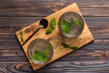 Sağlıklı kahvaltı ya da sabah chia tohumu ve nane arkaplanda, vejetaryen yiyecekler, diyet ve sağlık konsepti. Chia pudingi ve naneli.