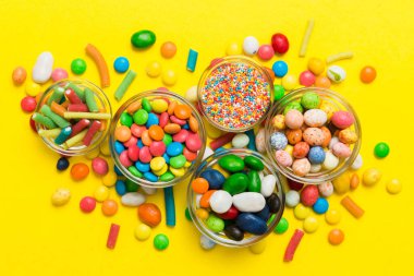 farklı renkte yuvarlak şekerler ve kavanozlar. Fotokopi alanı olan büyük çeşitlilikteki şeker ve şekerlerin üst görünümü.