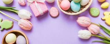 Yumurtalı Paskalya çerçevesi, renkli bir arka planda hediye kutusu ve lale. Minimum konsept. Üst Manzara Mutlu Paskalyalar kompozisyonu. Metin için yerin bir kopyasına sahip kart.