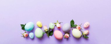 Mutlu Paskalyalar. Renkli masada sarı güllü Paskalya yumurtaları. Doğal boyalı renkli yumurtalar arkaplan arkaplan görünümü kopya alanı ile.