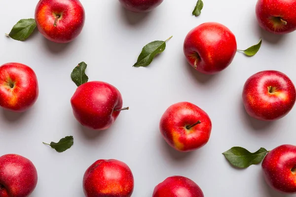 Renkli arka planda bir sürü kırmızı elma, üst manzara. Görüş üzerinde taze elma ile sonbahar deseni.
