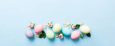 Mutlu Paskalyalar. Renkli masada sarı güllü Paskalya yumurtaları. Doğal boyalı renkli yumurtalar arkaplan arkaplan görünümü kopya alanı ile.