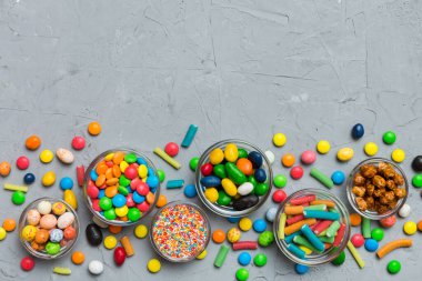 farklı renkte yuvarlak şekerler ve kavanozlar. Fotokopi alanı olan büyük çeşitlilikteki şeker ve şekerlerin üst görünümü.