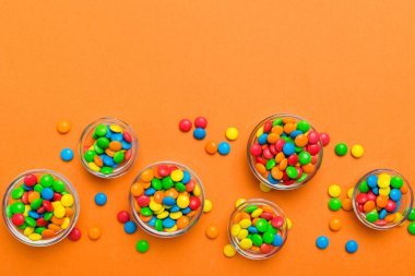 farklı renkte yuvarlak şekerler ve kavanozlar. Fotokopi alanı olan büyük çeşitlilikteki şeker ve şekerlerin üst görünümü.