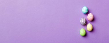 Bayram hazırlığı. Renkli arka planda Paskalya yumurtaları. Pastel renginde Paskalya yumurtası. Kopyalama alanı olan tatil kavramı.