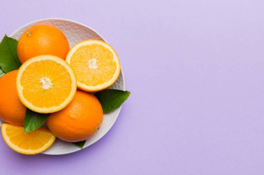 Renkli arka planda dilimlenmiş taze portakal meyvesi düzlüğü. Kopyalama alanı olan üst görünüm.