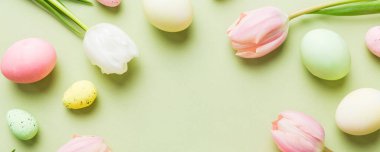 Mutlu Paskalya kompozisyonu. Renkli masada sarı laleli Paskalya yumurtaları. Doğal boyalı renkli yumurtalar arkaplan arkaplan görünümü kopya alanı ile.