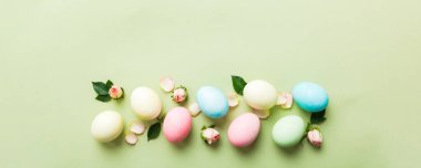 Mutlu Paskalyalar. Renkli masada sarı güllü Paskalya yumurtaları. Doğal boyalı renkli yumurtalar arkaplan arkaplan görünümü kopya alanı ile.