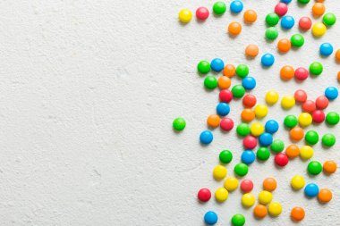 Renkli arka planda karışık renkli şeker koleksiyonu. Düz yerde, üst tarafta. Renkli çikolata kaplı şeker çerçevesi.