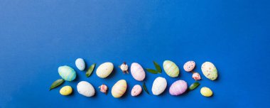 Happy Easter concept. Preparation for holiday. Easter eggs on colored background. flat lay top view copy space banner.