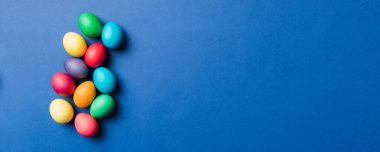 Bayram hazırlığı. Renkli arka planda Paskalya yumurtaları. Pastel renginde Paskalya yumurtası. Kopyalama alanı olan tatil kavramı.