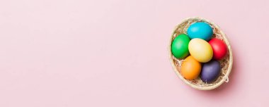 Renkli arka planda dokuma sepetinde çok renkli Paskalya yumurtaları. Pastel renginde Paskalya yumurtası. Kopyalama alanı olan tatil kavramı.