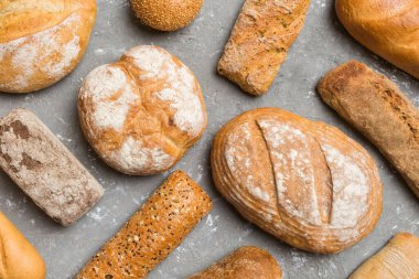 Ev yapımı doğal ekmek. Arka plan olarak farklı taze ekmek türleri, kopya alanı ile üst görünüm.
