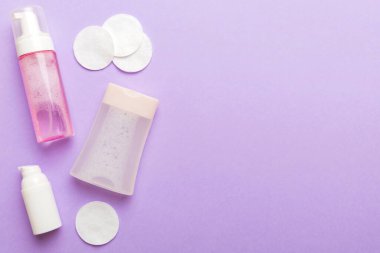 Kozmetikleri çıkarmak ve renkli arkaplandaki deriyi temizlemek için Micellar suyu ve diskleri temizler. Üst görünümü kopyala.