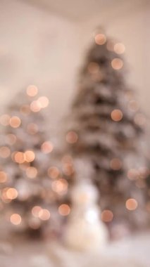 Işıkları parlayan bir Noel ağacının bulanık silüeti. Dikey video yılbaşı ağacını ışık ve süslemelerle çözdü. Samimi, soyut Noel konsepti.