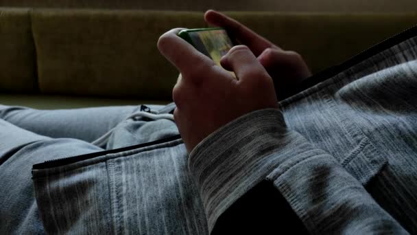 Man Eller Tonåring Sitter Soffan Hemma Och Spelar Onlinespel Med — Stockvideo