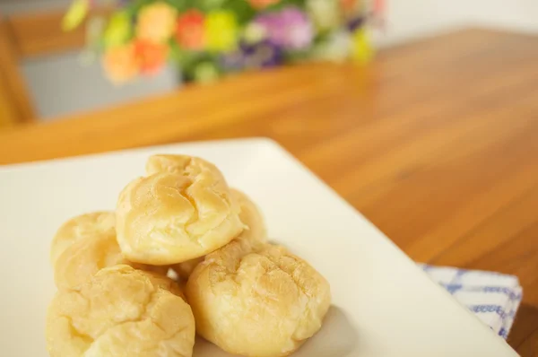 Eclair place crème dans l'assiette sur la table en bois — Photo