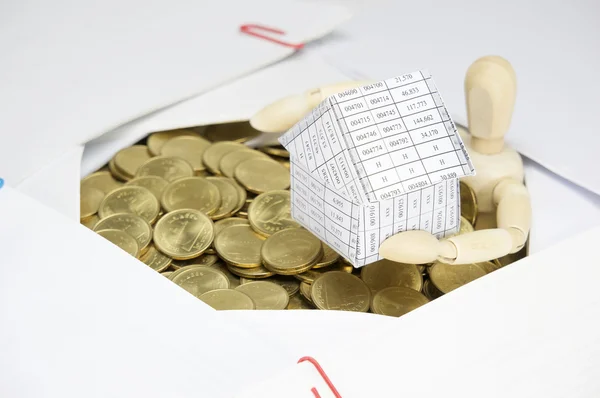 Altın sikke ve evrak ile çevrili ahşap kukla holding evi