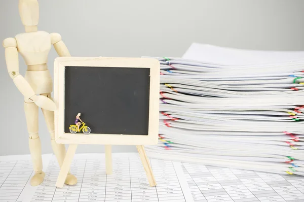 Wooden dummy holding empty blackboard with woman is cycling — Stock Photo, Image