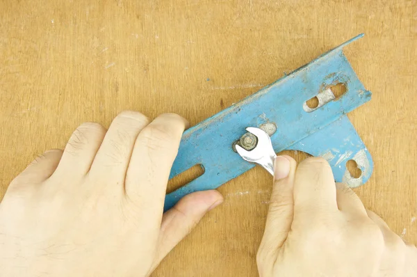 Man screw nut from old steel angle — Stock Photo, Image