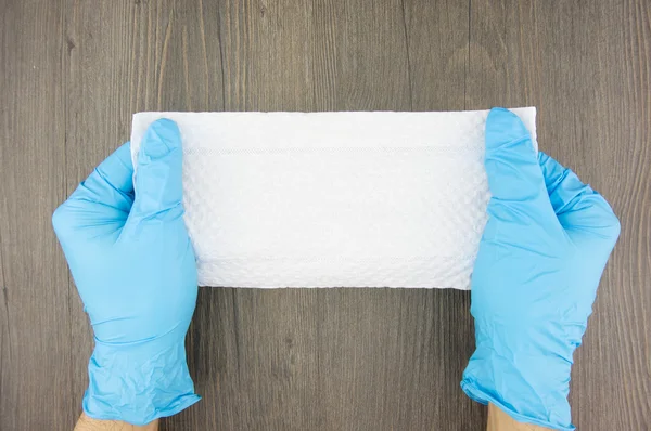 Homem usar luvas de látex azul segurando papel tissue — Fotografia de Stock