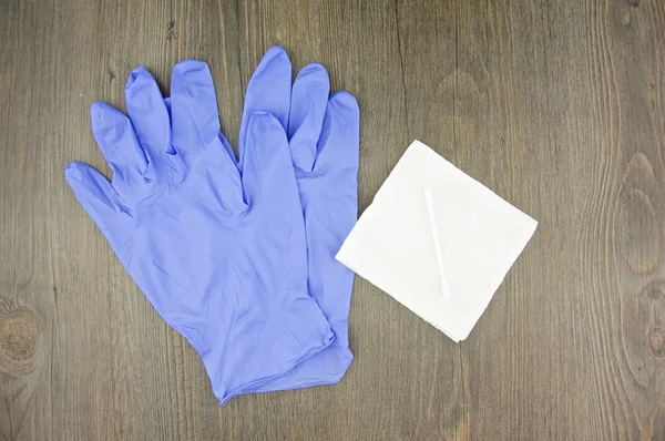 Luvas de látex roxo e broto de algodão sobre papel tissue — Fotografia de Stock