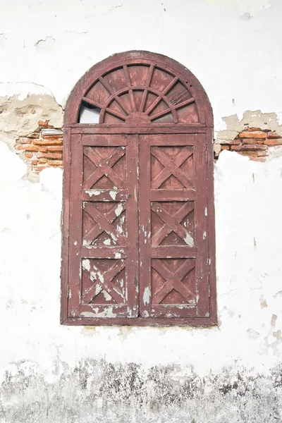 Old ancient brown window on damage wall — Stock Photo, Image