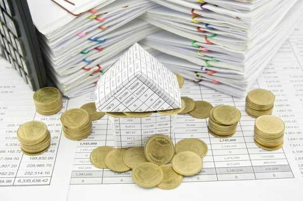 Huis en gouden munten overladen met calculator — Stockfoto