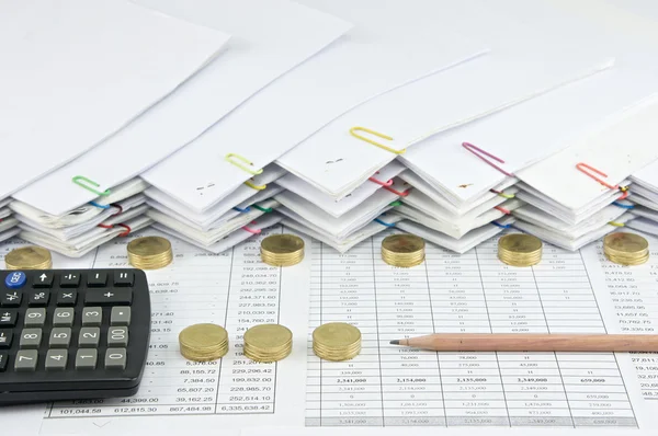 Bruin potlood met zwarte calculator tussen stapel van gouden munten — Stockfoto